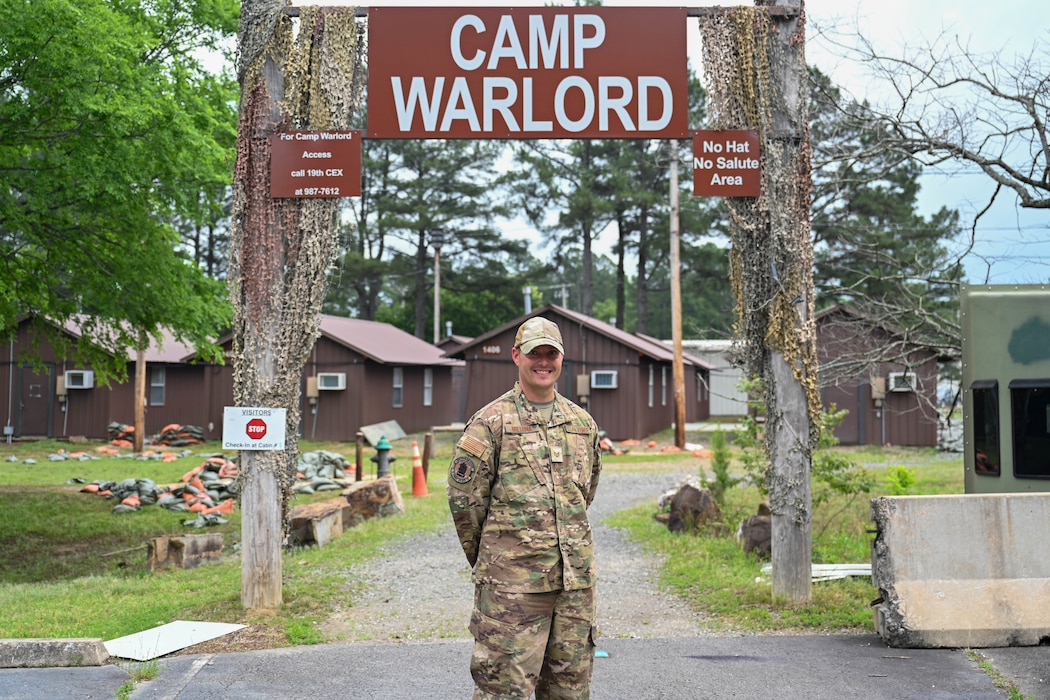 A man stands in front of "War Center" sign.