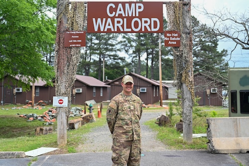 A man stands in front of "War Center" sign.
