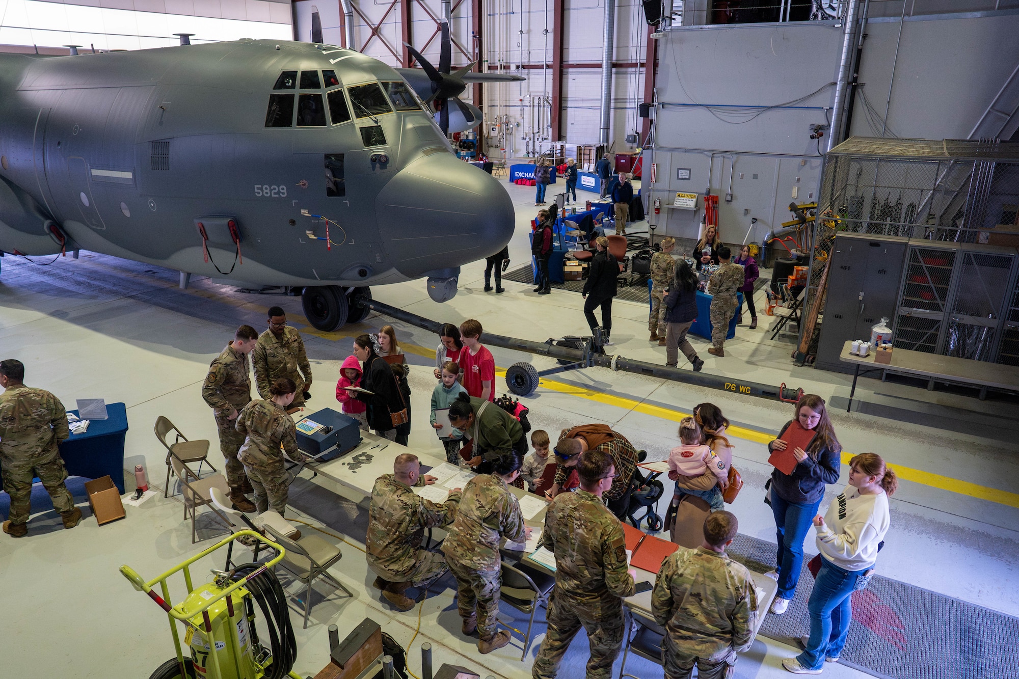 Joint Base Elmendorf-Richardson families stand in line during a family deployment line on JBER, Alaska, April 25, 2026. Families participating in the mock deployment explored aircraft, various career fields and resources, boosting morale for families and friends of deployed service members. (U.S. Air Force photo by Airman 1st Class Keola Vischi)