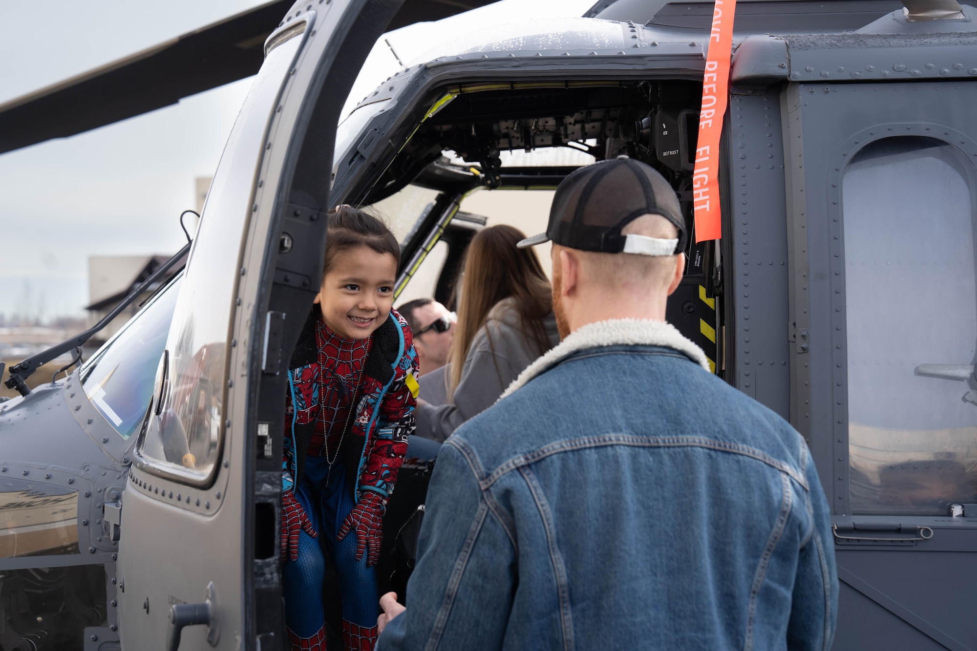 Families on Joint Base Elmendorf-Richardson sit inside a cockpit of a U.S. Air Force HH-60 Pavehawk static display during a family deployment line on JBER, Alaska, April 25, 2026. For Month of the Military Child, JBER hosted a family deployment line to boost morale, reflecting procedures in a real-world deployment scenario. The interactive display gave military children an up-close look at rescue aircraft to help them better understand the critical roles their families play in supporting rescue operations and readiness. (U.S. Air Force photo by Airman 1st Class Keola Vischi)