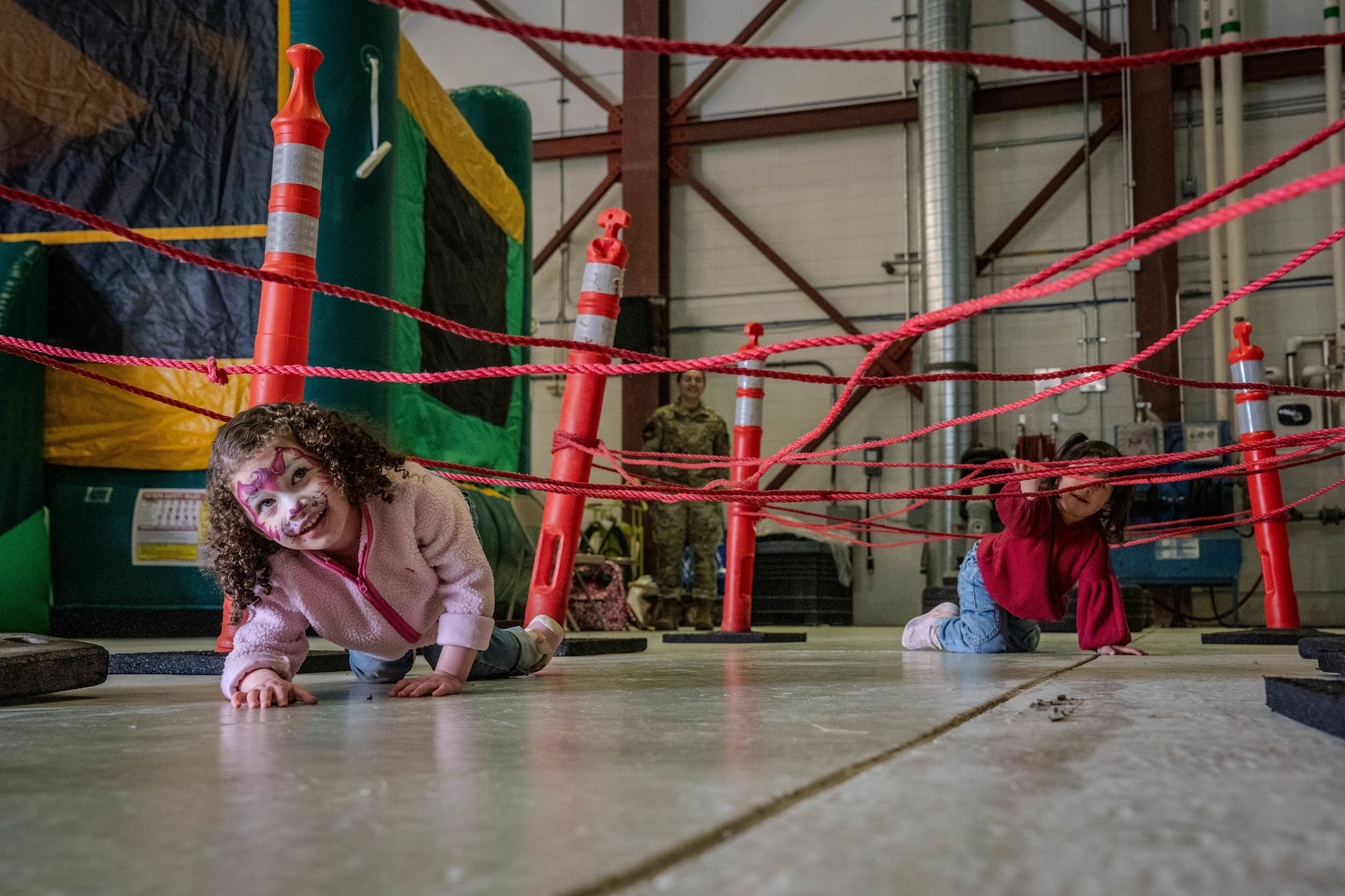 Children on Joint Base Elmendorf-Richardson crawl through an obstacle course during a family deployment line on JBER, Alaska, April 25, 2026. During the morale-boosting event, families participated in various activities including a mock firing range test, obstacle courses and safety equipment issue reflecting the training Airmen go through for real-world pre-deployment scenarios. (U.S. Air Force photo by Airman 1st Class Airman Keola Vischi)
