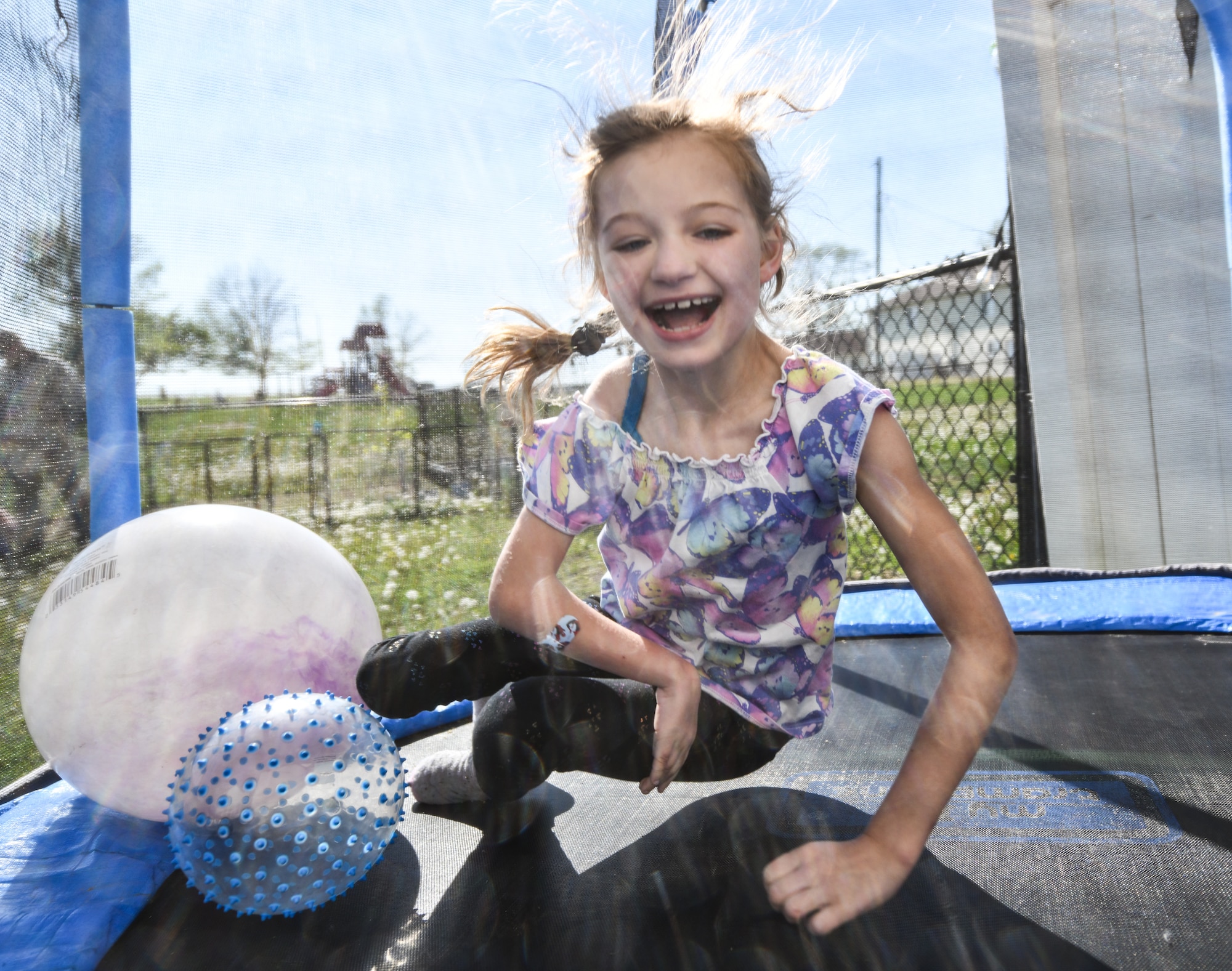 Hannah bounces on a trampoline in her backyard on April 24, 2026. Even with limited mobility from cerebral palsy, Hannah enjoys playing like everyone else. (U.S. Air Force photo by Chad Watkins)