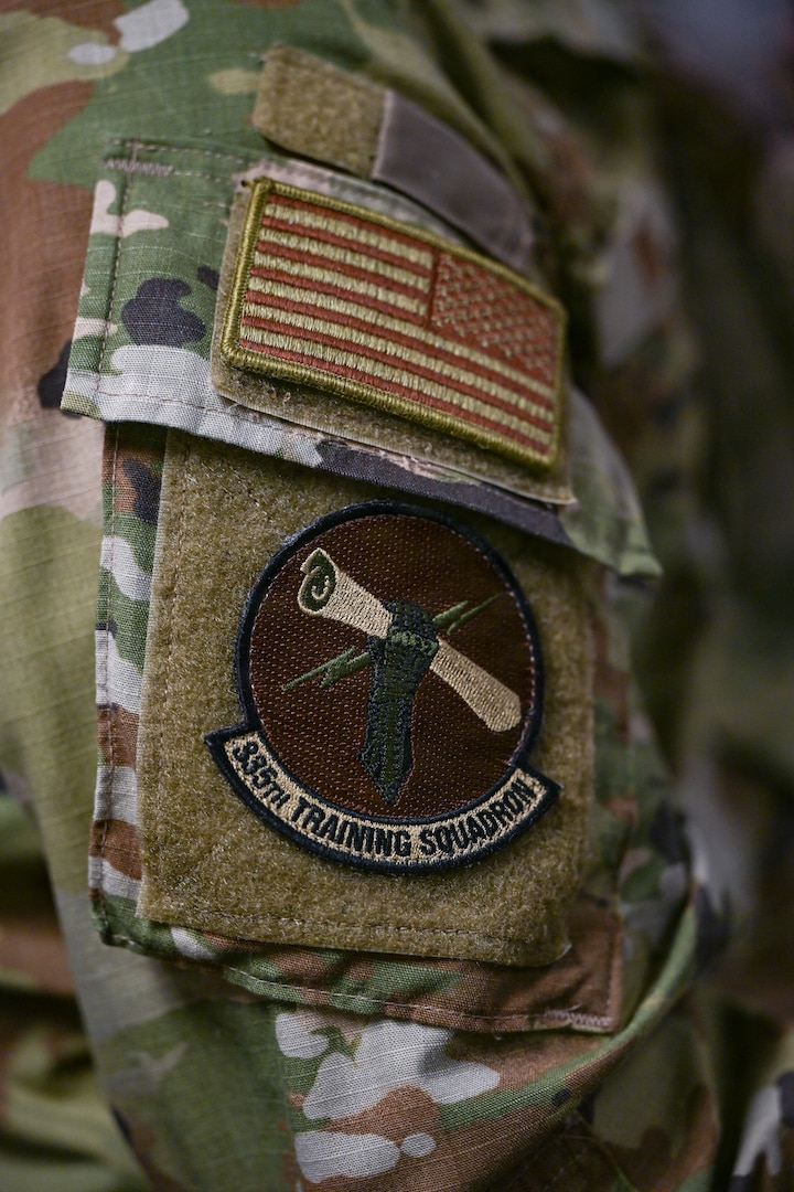 A person in military uniform is displayed in a classroom.