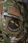 A person in military uniform is displayed in a classroom.