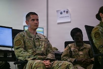 A person in military uniform is displayed in a classroom.