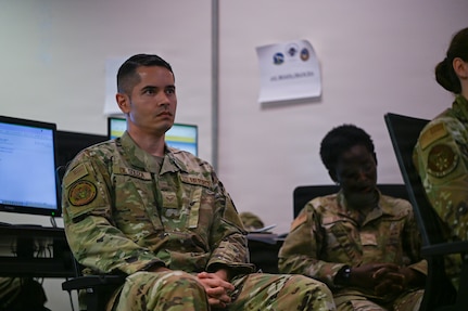 A person in military uniform is displayed in a classroom.