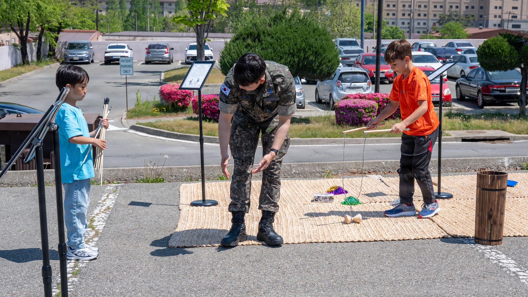 A Republic of Korea airman instructs a child during the K-Culture Day event at Osan Air Base, ROK, April 30, 2026. The event featured traditional Korean performances, hands-on activities and cultural experiences designed for all ages. (U.S. Air Force photo by Senior Airman Rome Bowermaster)