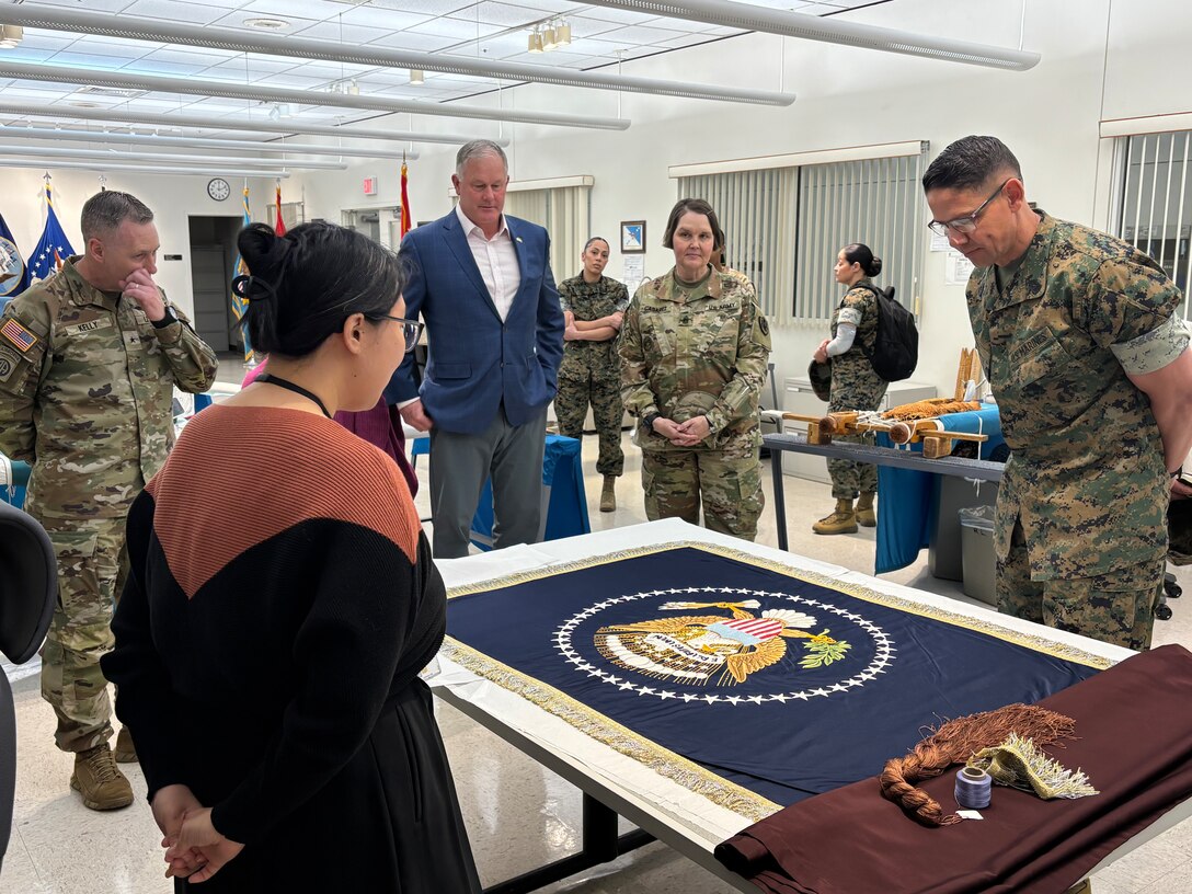 Sergeant Major of the Marine Corps Carlos Ruiz examines a nearly completed Presidential flag during a visit to Defense Logistics Agency Troop Support in Philadelphia on April 27. His visit included a tour of the flag room.