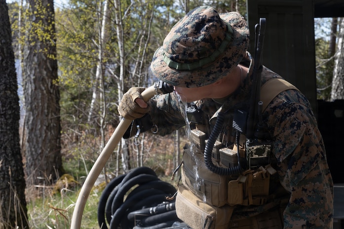 U.S. Marine Corps 1st Lt. Jack Mion, a combat engineer officer with Combat Logistics Battalion 24, Combat Logistics Regiment 27, 2nd Marine Logistics Group, drinks purified water during exercise Aurora 26 in Kvarn, Sweden, April 26, 2026. U.S. Marines use portable, rugged, and energy‑efficient water purification systems to provide safe drinking water in austere or combat environments. U.S. Marines and Sailors with 2nd MLG are participating in exercise Aurora as part of the larger U.S. Army-led Sword 26 series of linked multinational exercises, which directly supports NATO's Eastern Flank Deterrence Initiative concept, validates defense plans, builds a unified lethal force, and strengthens deterrence. Mion is a native of New York. (U.S. Marine Corps photo by Lance Cpl. Talan Werner)