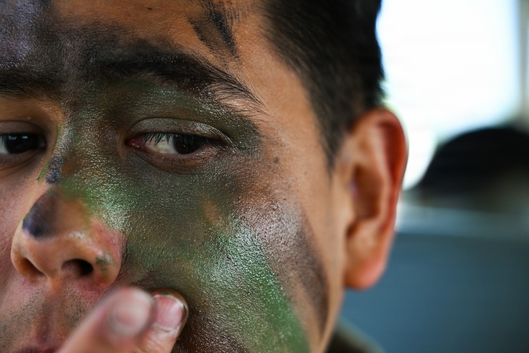 U.S. Air Force Senior Airman Axel Ayala, 316th Wing Security Forces Squadron patrolman, applies camouflage during an Airman Leadership School field training exercise at Marine Corps Base Quantico, Virginia, April 24, 2026.