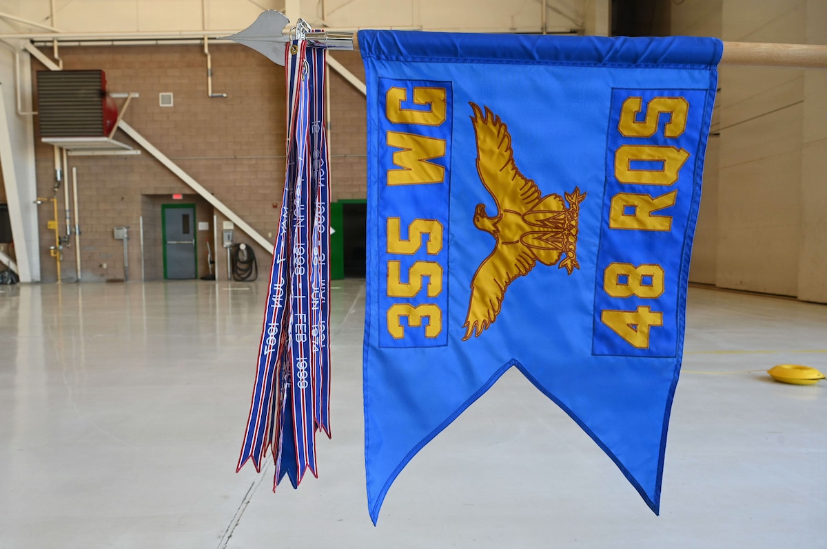 The 48th Rescue Squadron guidon receives a new streamer during a Presidential Unit Citation ceremony at Davis-Monthan Air Force Base, Arizona, April 17, 2026. For hundreds of years, guidons have represented large formations and specific units within a military branch. Streamers denote a unit’s service, battle honors or decorations. (U.S. Air Force photo by Staff Sgt. Kahdija Slaughter)