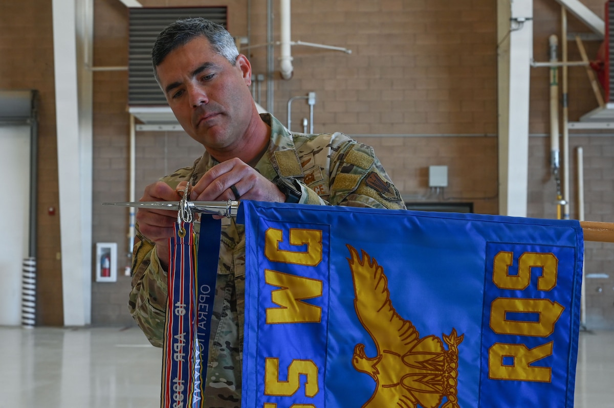 U.S. Air Force Col. Jose Cabrera, 355th Wing commander, places a new Operation Allies Refuge streamer on the 55th Rescue Squadron guidon during a Presidential Unit Citation ceremony at Davis-Monthan Air Force Base, Arizona, April 17, 2026. The campaign streamer denotes the unit’s service and battle honors earned during unconventional combat search and rescue operations in support of the final withdrawal of U.S. troops from Afghanistan, resulting in the safe evacuation of 124,000 people between July 16 and Aug. 31, 2021. (U.S. Air Force photo by Staff Sgt. Kahdija Slaughter)