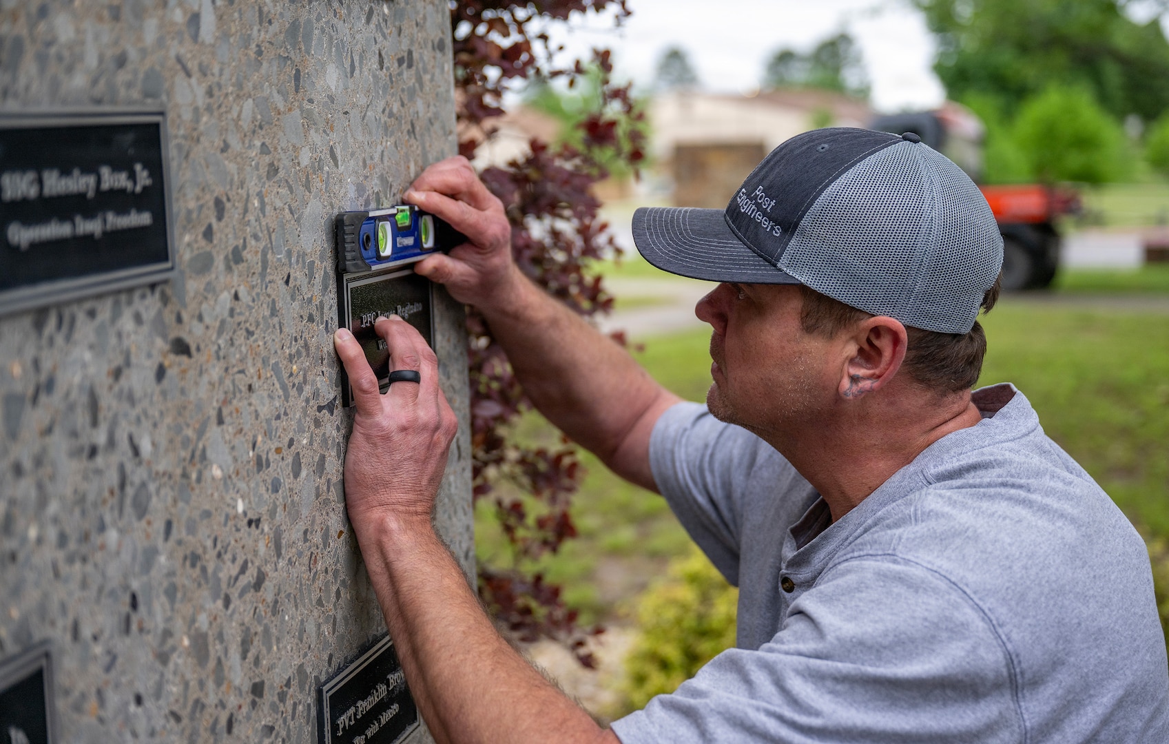 Arkansas Deptartment of the Military employee Kevin Shaffer installs a plaque April 29, 2026, that honors Pfc. James Reginato who was injured by enemy fire in Mignano, Italy, on Dec. 15, 1943.