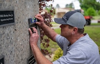 Arkansas Deptartment of the Military employee Kevin Shaffer installs a plaque April 29, 2026, that honors Pfc. James Reginato who was injured by enemy fire in Mignano, Italy, on Dec. 15, 1943.