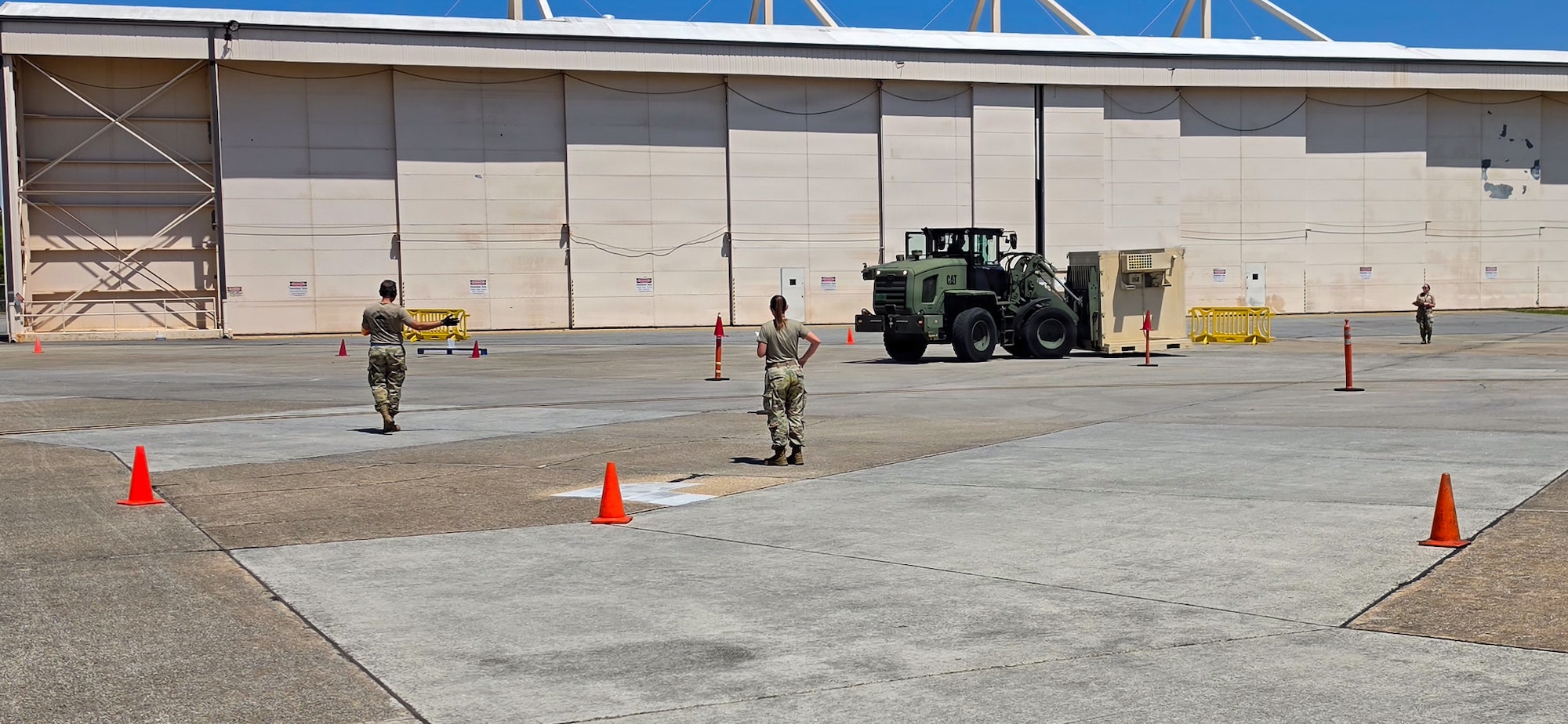 Three Airmen working on a pallet and equipment.