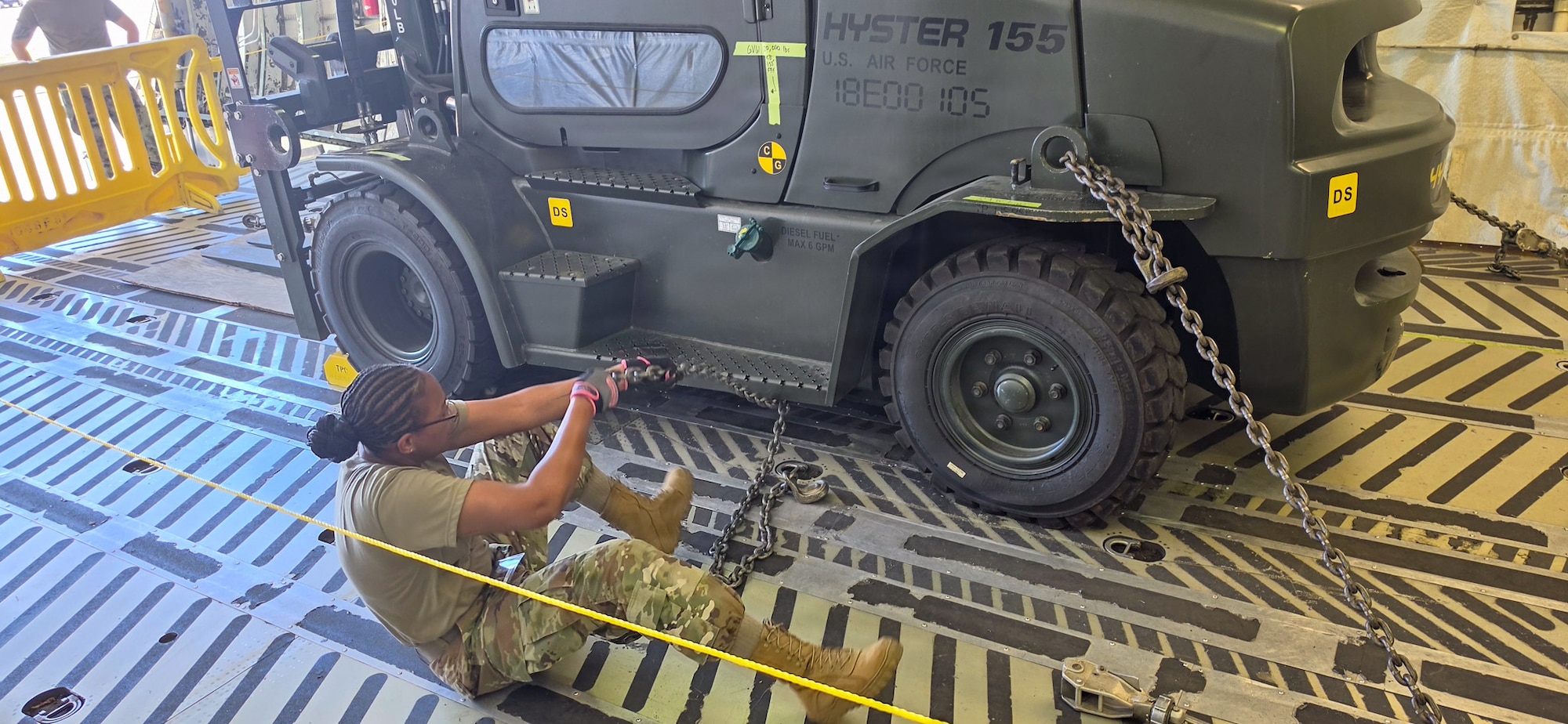 Three Airmen working on a pallet and equipment.