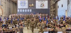 Three Airmen working on a pallet and equipment.