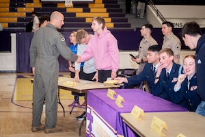 Col. Chad Backes, 55th Wing deputy commander, shakes hands with a student military recruit at Bellevue West High School in Bellevue, Neb., April 22, 2026. Families, friends, teachers, faculty members, and military recruiters attended the event to show support for the high schoolers who are committing to military service after graduation. (U.S. Air Force photo by Daniel Martinez)