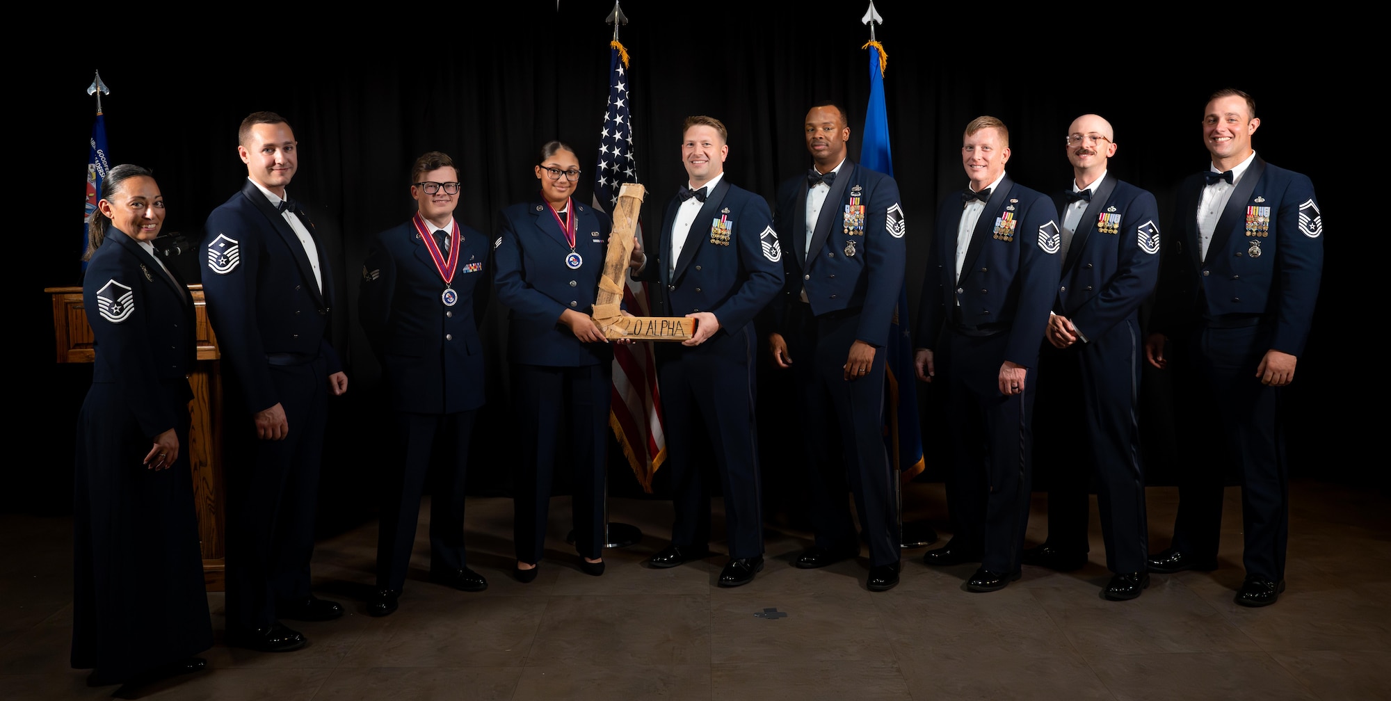 U.S. Air Force Senior Airman Raizel Neal, 47th Operation Support Squadron air traffic control trainer, and U.S. Air Force Staff Sgt. Keith Brothers 315th Training Squadron geospatial intelligence instructor hand Laughlin leadership the “L” award during Airman Leadership School Class 26-C’s graduation at Laughlin Air Force Base, Texas, April 29, 2026. The “L” award is a tradition presented to the losers of the Airman leadership School volleyball tournament. (U.S. Air Force photo by Airman 1st Class Harrison Sullivan)
