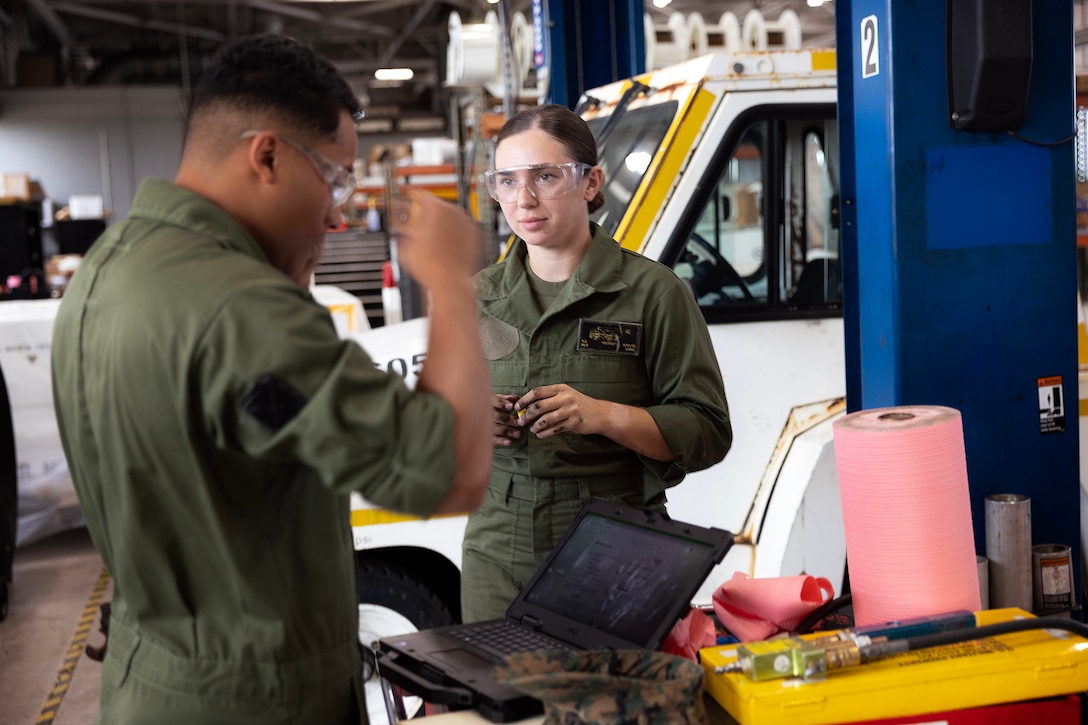 U.S. Marine Corps Sgt. Christopher Canaleshall, left, of Clewiston, Florida, and Sgt. Sarah Soucie of Eureka, Missouri, aviation mechanics designated as quality assurance representatives with Blount Island Command, prepare to inflate a tire on a mid-range tow tractor during training April 30 at Naval Air Station Jacksonville, Florida. The training requalified the Marines in aviation support equipment tire and wheel maintenance, strengthening their ability to support maritime prepositioning readiness. (U.S. Marine Corps photo by Dustin Senger)