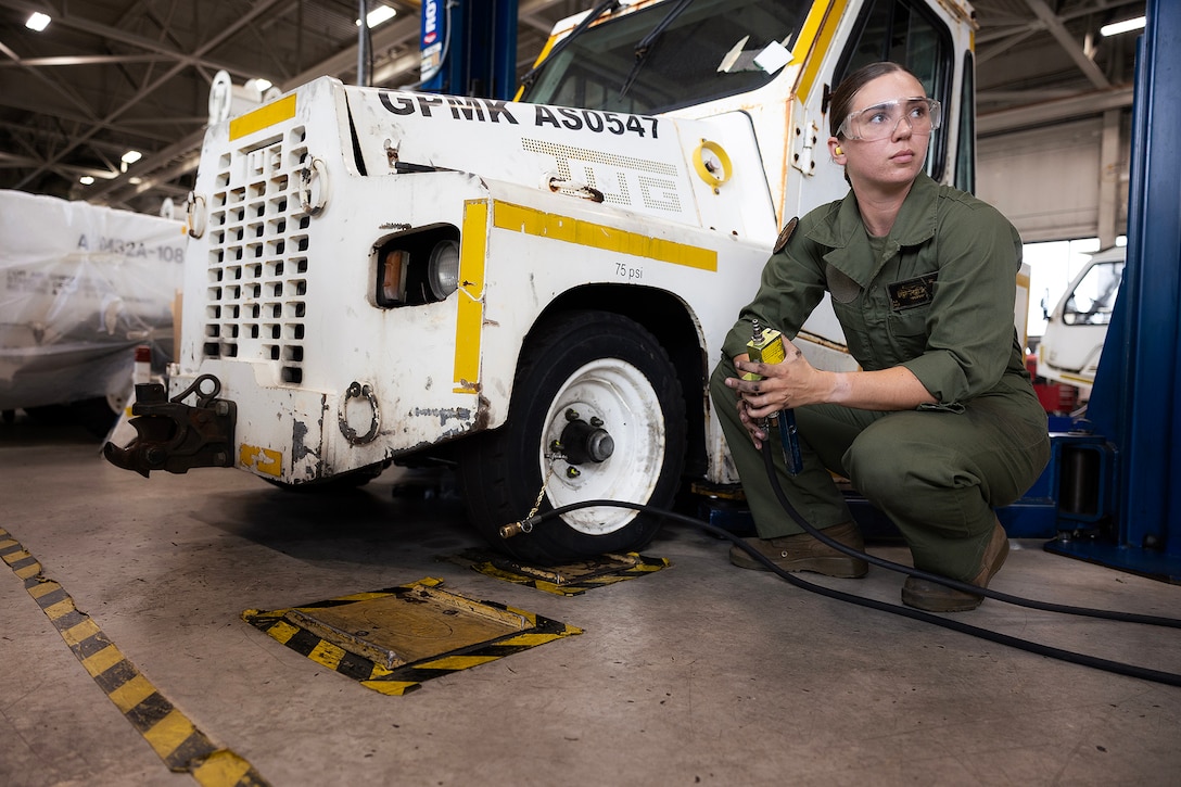 U.S. Marine Corps Sgt. Christopher Canaleshall, left, of Clewiston, Florida, and Sgt. Sarah Soucie of Eureka, Missouri, aviation mechanics designated as quality assurance representatives with Blount Island Command, inflate a tire on a mid-range tow tractor during training April 30 at Naval Air Station Jacksonville, Florida. The training requalified the Marines in aviation support equipment tire and wheel maintenance, strengthening their ability to support maritime prepositioning readiness. (U.S. Marine Corps photo by Dustin Senger)