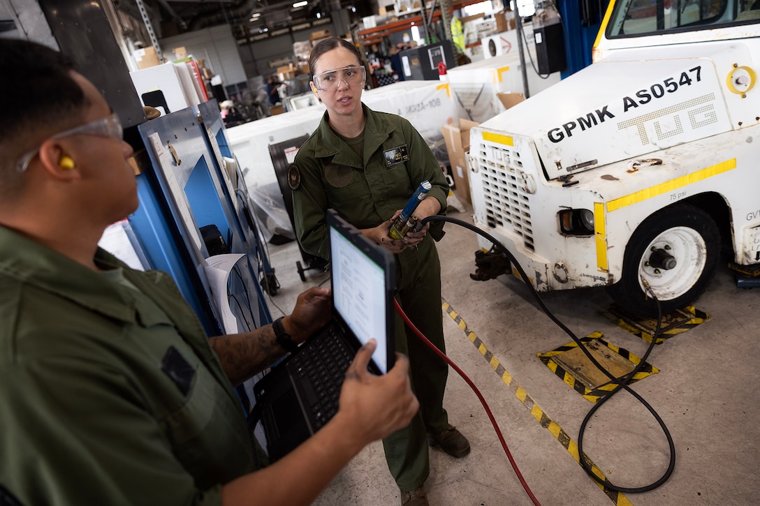 U.S. Marine Corps Sgt. Christopher Canaleshall, left, of Clewiston, Florida, and Sgt. Sarah Soucie of Eureka, Missouri, aviation mechanics designated as quality assurance representatives with Blount Island Command, inflate a tire on a mid-range tow tractor during training April 30 at Naval Air Station Jacksonville, Florida. The training requalified the Marines in aviation support equipment tire and wheel maintenance, strengthening their ability to support maritime prepositioning readiness. (U.S. Marine Corps photo by Dustin Senger)