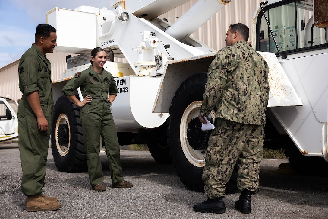 U.S. Marine Corps Sgt. Christopher Canaleshall of Clewiston, Florida, and Sgt. Sarah Soucie of Eureka, Missouri, aviation mechanics designated as quality assurance representatives with Blount Island Command, discuss tire maintenance on a wheeled crane with Navy Petty Officer 1st Class Matthew Abdoran, a ground support equipment instructor, during training April 30 at Naval Air Station Jacksonville, Florida. The training requalified Marines in aviation support equipment tire and wheel maintenance in support of maritime prepositioning readiness. (U.S. Marine Corps photo by Dustin Senger)