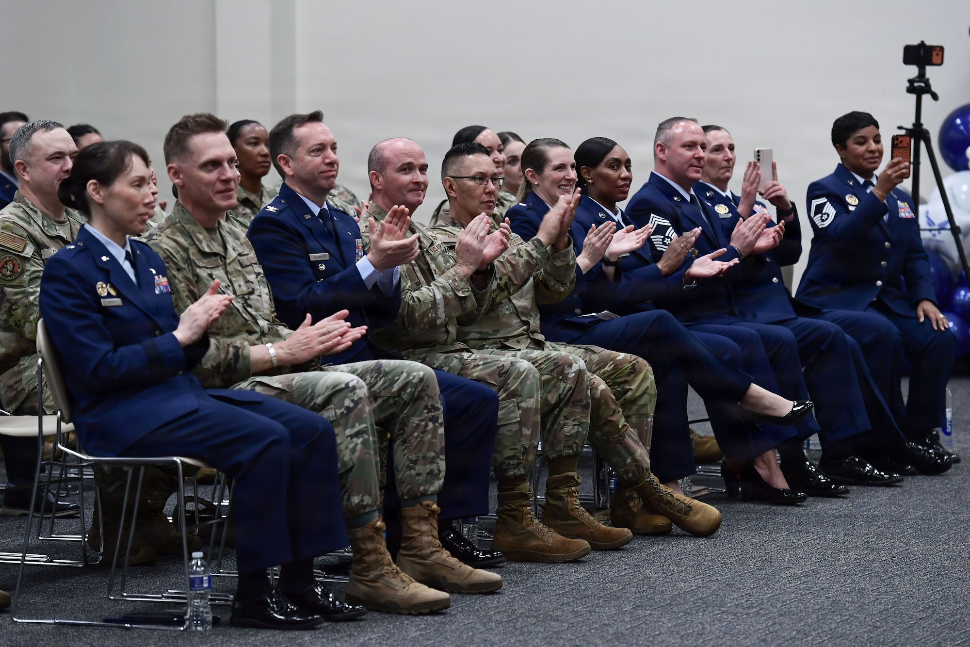 U.S. Airmen applaud from the audience.