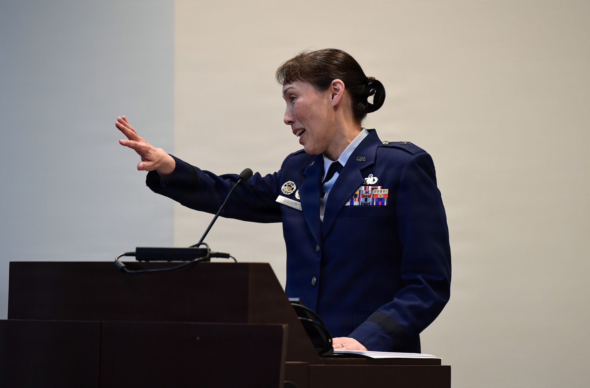 An Air Force woman speaks from behind a podium.