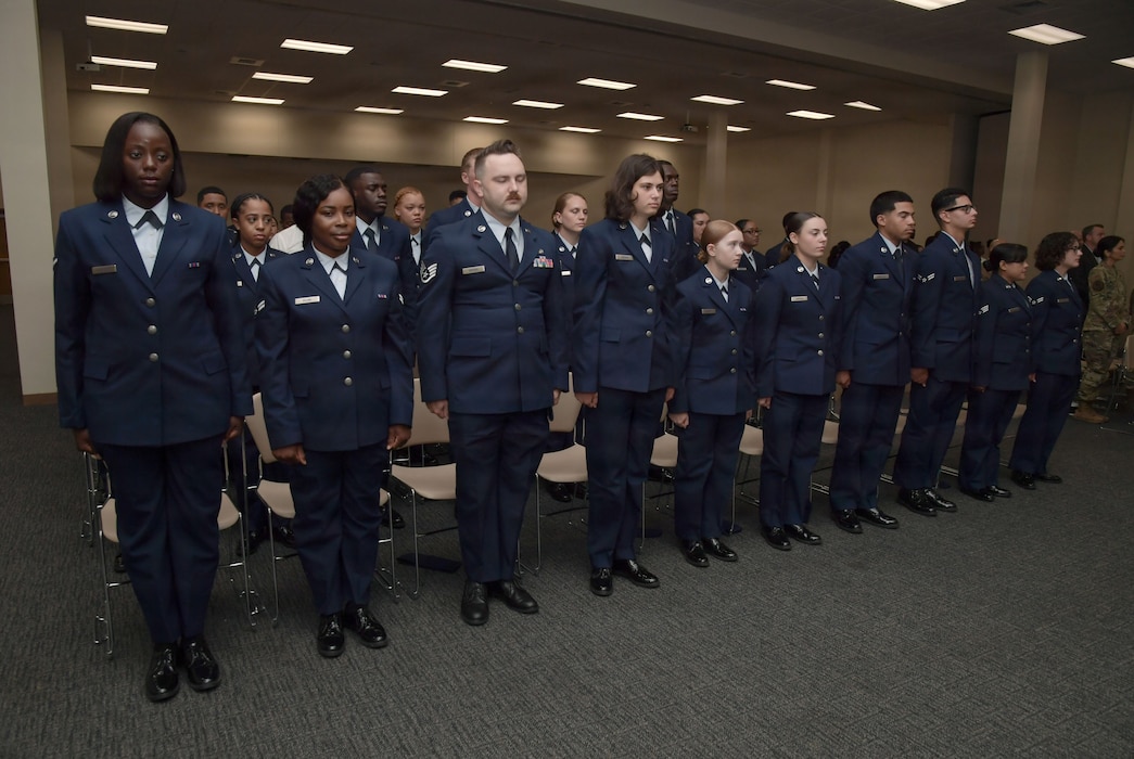 Airmen stand in a row in uniform.