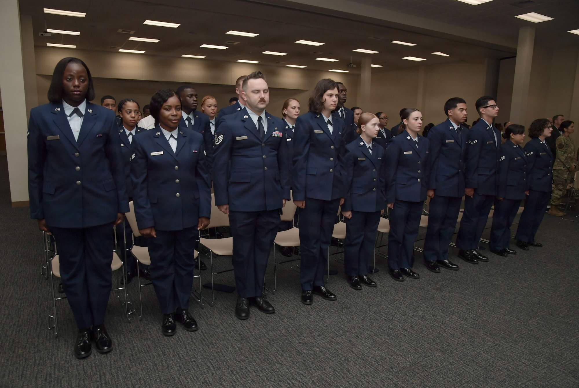 Airmen stand in a row in uniform.