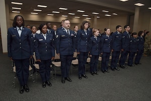 Airmen stand in a row in uniform.
