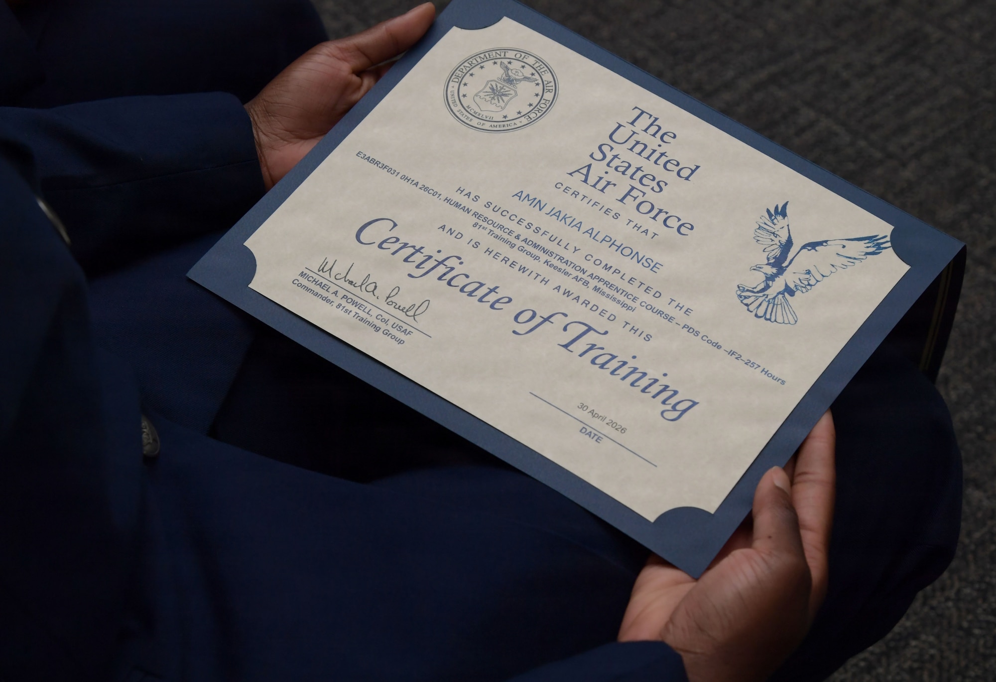 A U.S. Airmen holds a certificate.