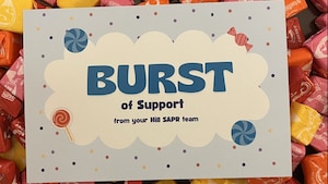 An overhead view of colorful Starburst candies with a promotional card for the Hill AFB SAPR office laid on top.