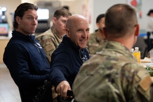 Packy Lyden, Air and Space Forces Aid Society chief development officer, left, and U.S. Air Force  Maj. Gen. Ed Thomas,  AFAS chief executive officer, center, speak with an Airman about AFAS programs at Davis-Monthan Air Force Base, Arizona, April 29, 2026. AFAS provides support to Airmen, Guardians and their families through emergency assistance and quality-of-life programs. (U.S. Air Force photo by Airman 1st Class Jaden Kidd)