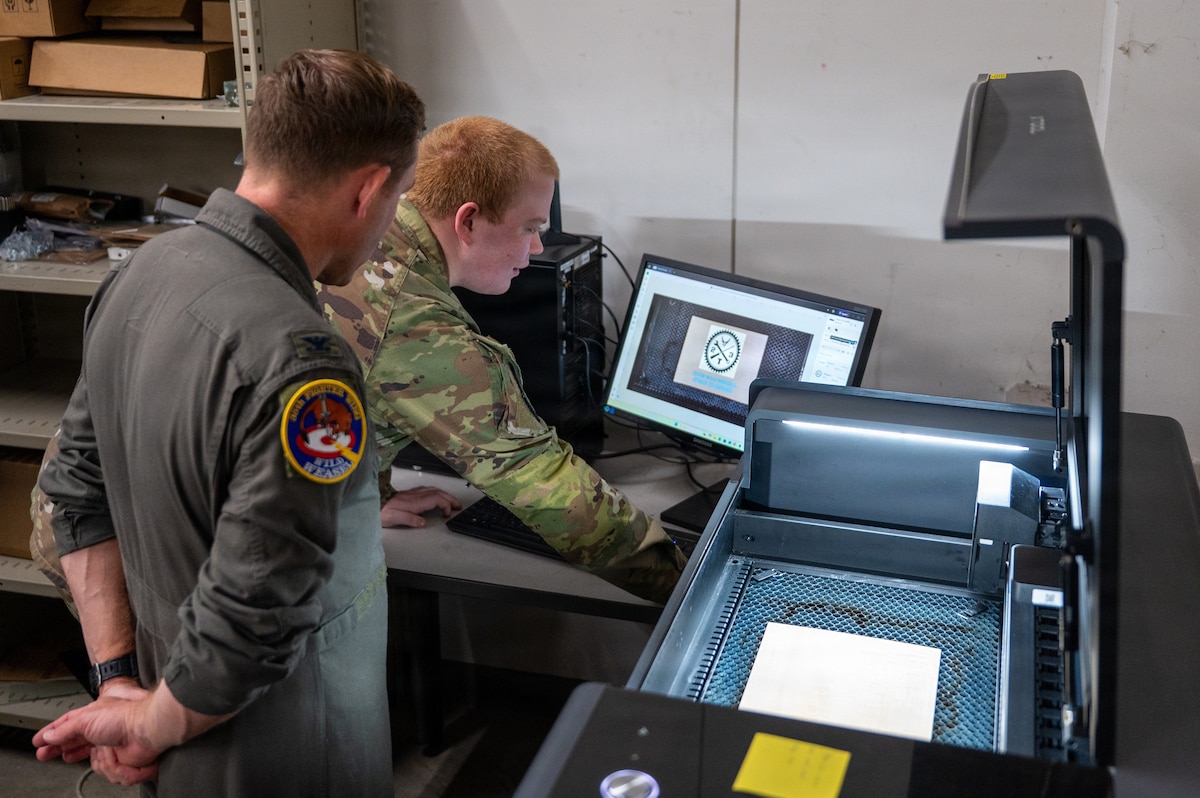 U.S. Air Force Airman 1st Class Zachary Wilkinson, right, 35th Logistics Readiness Squadron fleet management and analysis technician, demonstrates printing capabilities to Col. Paul Davidson, 35th Fighter Wing (FW) commander, during a Wild Weasel Walk-through at Misawa Air Base, Japan, April 27, 2026. Davidson selected Wilkinson  as Wild Weasel of the Week for his professionalism and dedication to supporting installation needs and enhancing 35th FW readiness. (U.S. Air Force photo by Airman 1st Class Angelica Winther)