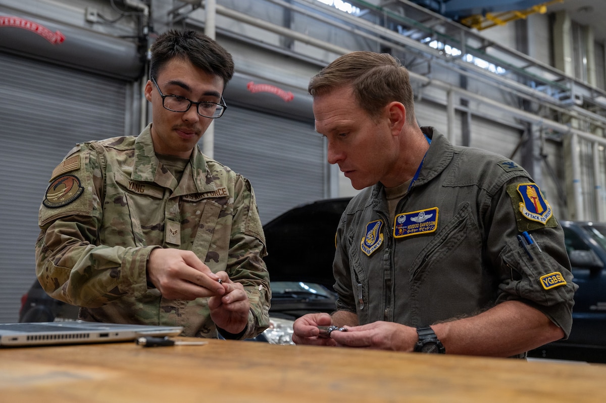 U.S. Air Force Airman 1st Class Lucus Yang, left, 35th Logistics Readiness Squadron fleet management and analysis technician, demonstrates specialized tool usage to Col. Paul Davidson, 35th Fighter Wing commander, at Misawa Air Base, Japan, April 27, 2026. He highlighted maintenance processes and equipment used to support fleet operations, helping ensure vehicles remain reliable and available for installation-wide operations. (U.S. Air Force photo by Airman 1st Class Angelica Winther)