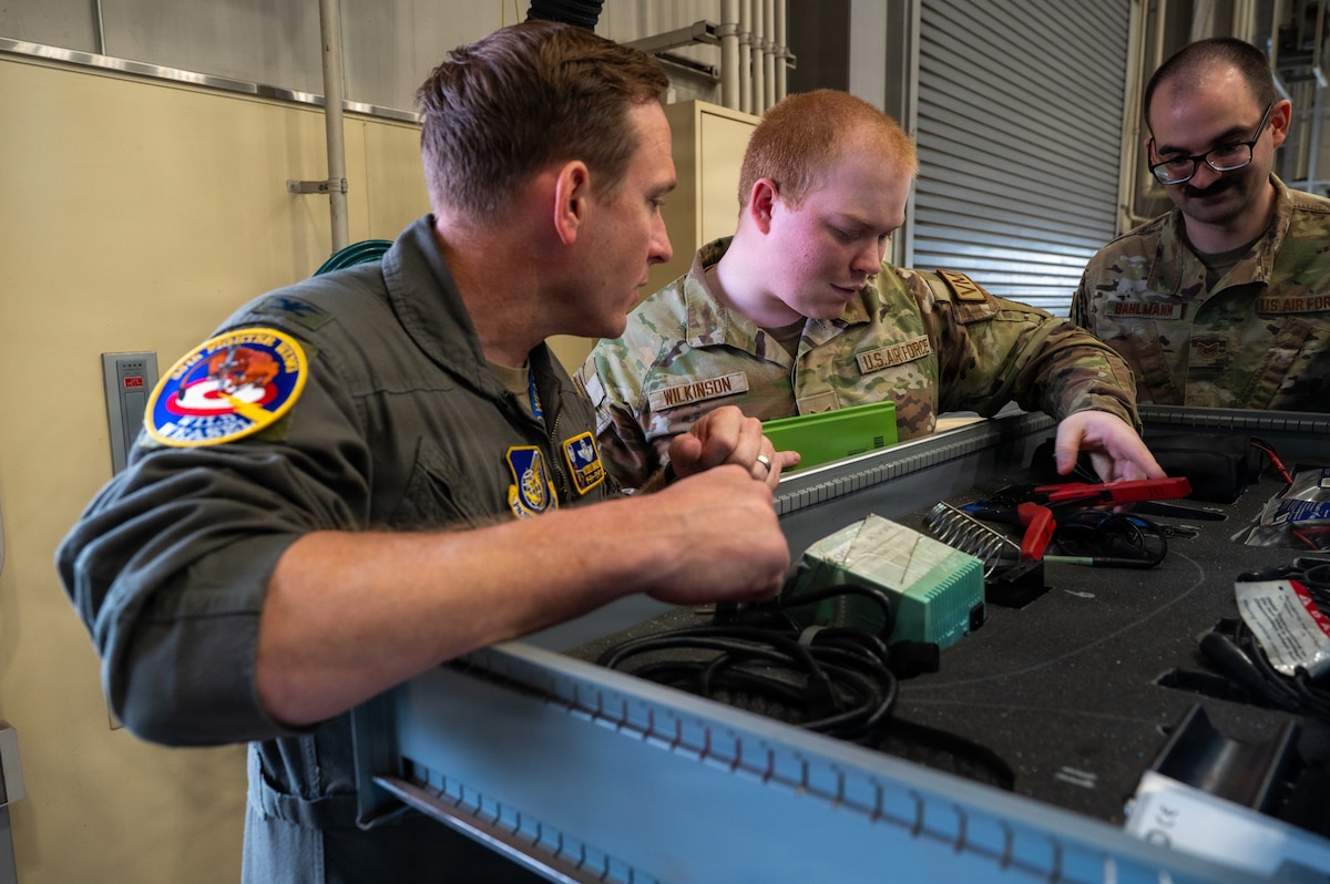 U.S. Air Force Airman 1st Class Zachary Wilkinson, center, 35th Logistics Readiness Squadron fleet management and analysis technician, discusses equipment with Col. Paul Davidson, left, 35th Fighter Wing commander, and Tech. Sgt. Morgan Bahlmann, 35th Logistics Readiness Squadron noncommissioned officer in charge of general purpose maintenance, at Misawa Air Base, Japan, April 27, 2026. Wilkinson highlighted maintenance tools and capabilities used to support fleet operations, helping ensure vehicles and equipment remain reliable for day-to-day operations across the installation. (U.S. Air Force photo by Airman 1st Class Angelica Winther)