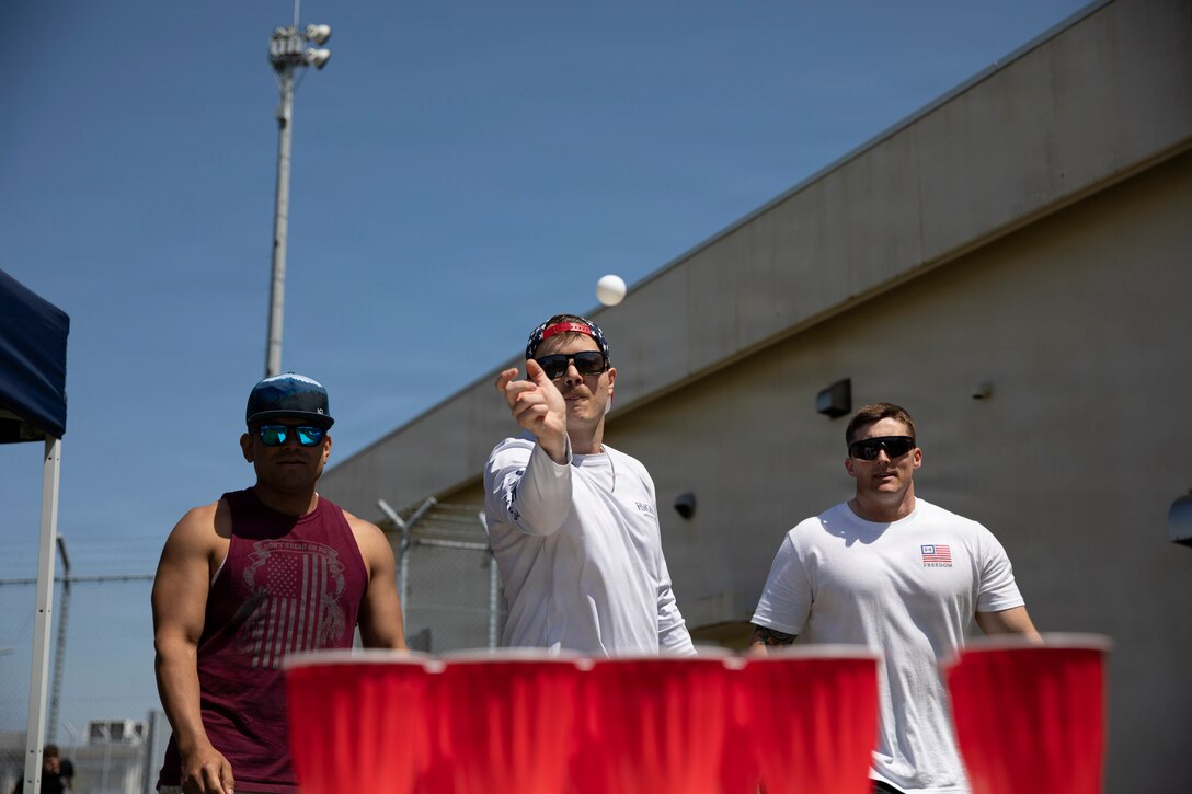 U.S. Marines with Marine Fighter Attack Squadron (VMFA) 242, Marine Aircraft Group 12, 1st Marine Aircraft Wing, throw a ping pong balls as part of an event during a race at Marine Corps Air Station Iwakuni, Japan, April 25, 2026. The American Red Cross and United Service Organizations hosted the Incredible Race, where participants had to overcome 8 different events across the air station, solving riddles to find the events location. (U.S. Marine Corps photo by Sgt. Peter Rawlins)