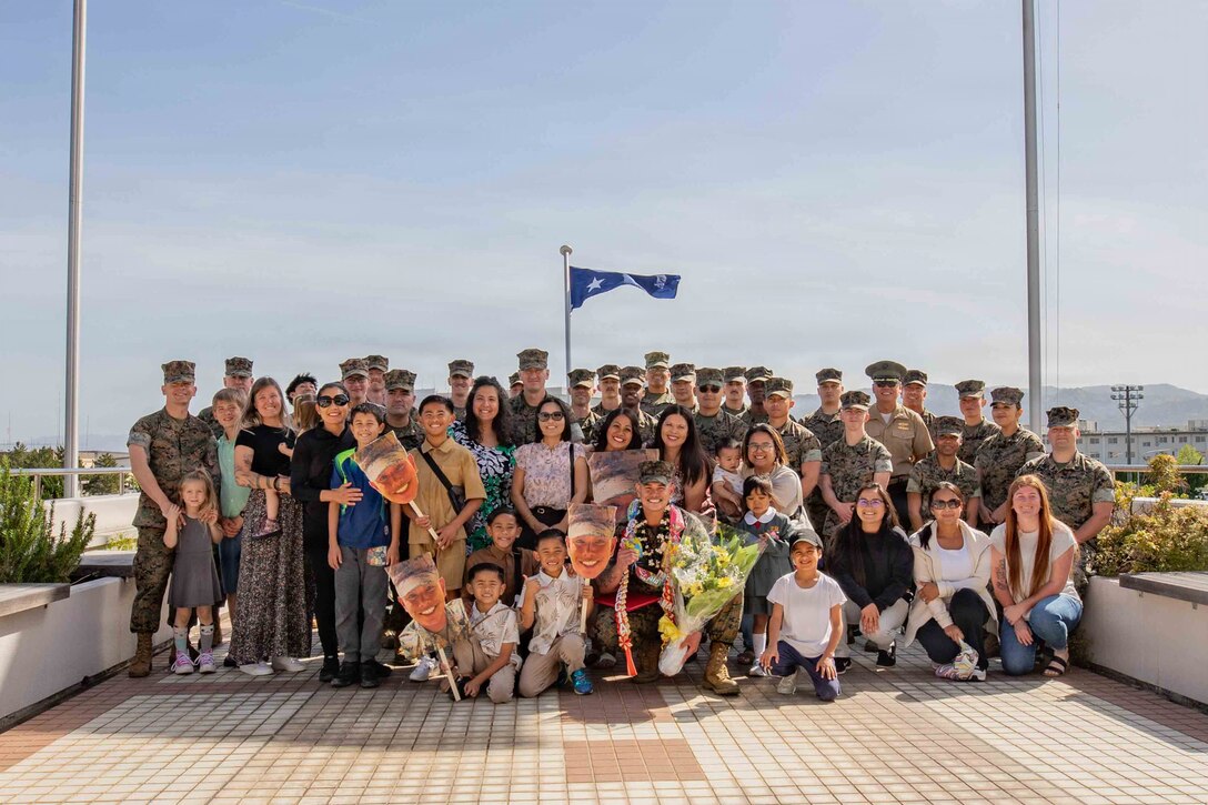 U.S. Marine Corps Gunnery Sgt. Martin Garcia, center, a supply chain manager with Marine Wing Support Squadron (MWSS) 171, Marine Aircraft Group 12, 1st Marine Aircraft Wing, and a native of California, poses for a photo with friends and family after the April 2026 Impact Iwakuni award ceremony at Marine Corps Air Station Iwakuni, Japan, April 21, 2026. The Impact Iwakuni award is presented monthly to recipients that make a significant positive impact on the community. (U.S. Marine Corps photo by Lance Cpl. Tyler Bassett)