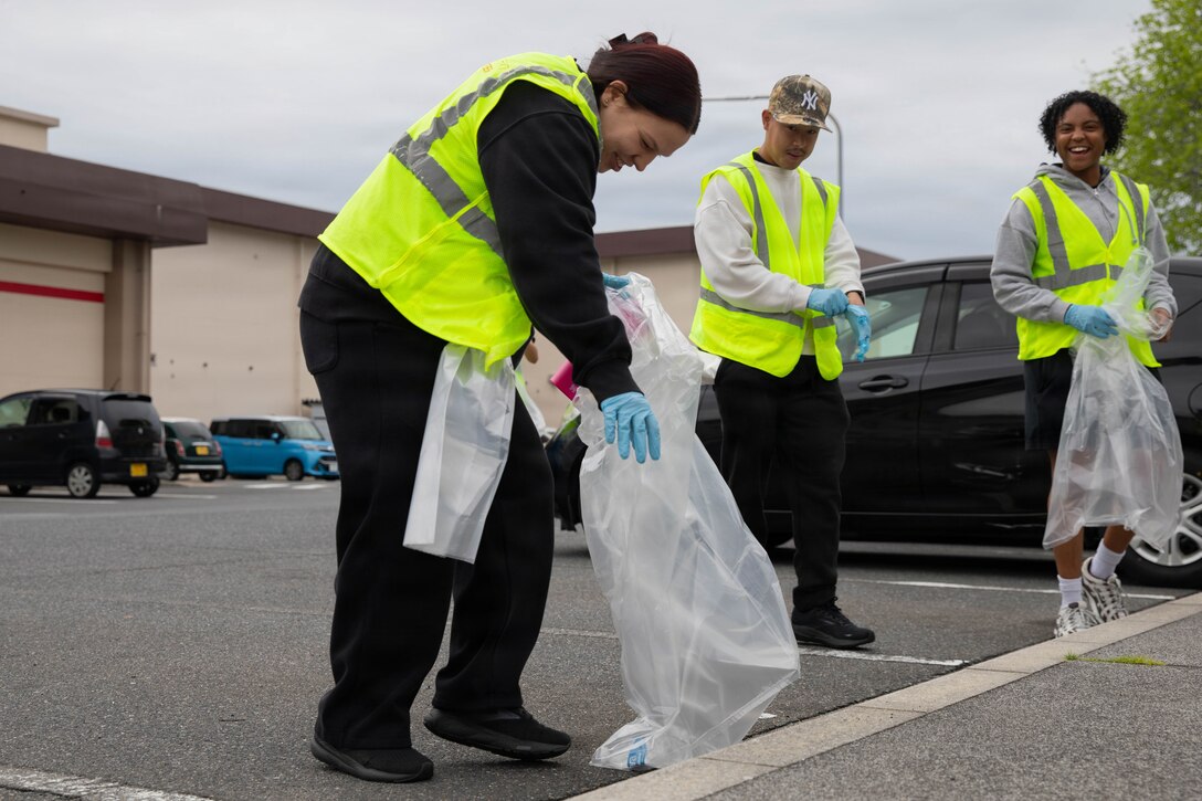 U.S. Navy Aviation Maintenance Administrationman Alexandra Ulbrich, left, with Aircraft Intermediate Maintenance Detachment Iwakuni, and a native of Charleston, South Carolina, picks up trash during a volunteer clean-up event hosted by the Marine Corps Air Station Iwakuni Single Marine Program at MCAS Iwakuni, Japan, April 24, 2026. The MCAS Iwakuni SMP hosted a clean-up as part of the SMP Days of Service, a five-day clean-up event to improve community relations both on and off the installation. (U.S. Marine Corps photo by Lance Cpl. Siwan Lewis)