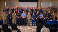 U.S. and Royal Canadian servicemembers pose for a group photo during the Atlantic Maritime Security Coalition (AMSC) final planning conference at Vista Point on Naval Station Norfolk, April 28, 2026.