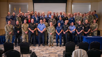 U.S. and Royal Canadian servicemembers pose for a group photo during the Atlantic Maritime Security Coalition (AMSC) final planning conference at Vista Point on Naval Station Norfolk, April 28, 2026.