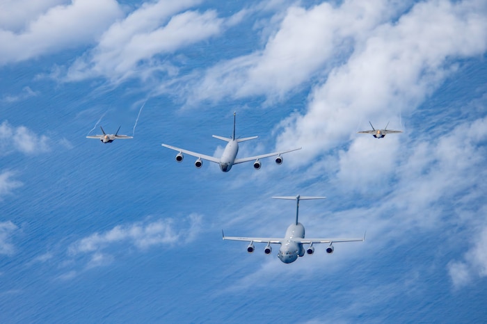 Airmen assigned to the 154th Operations Group, 154th Wing, Hawaii Air National Guard, operate U.S. Air Force aircraft during a multi-ship formation flight off the coast of Hawaii, Jan. 5, 2026. The formation included a C-17 Globemaster III assigned to the 15th Wing, and a KC-135 Stratotanker and two F-22 Raptors assigned to the 154th Wing, demonstrating total force integration and synchronized airlift, aerial refueling and fighter capabilities. (U.S. Air National Guard photo by Senior Master Sgt. Mysti Bicoy)