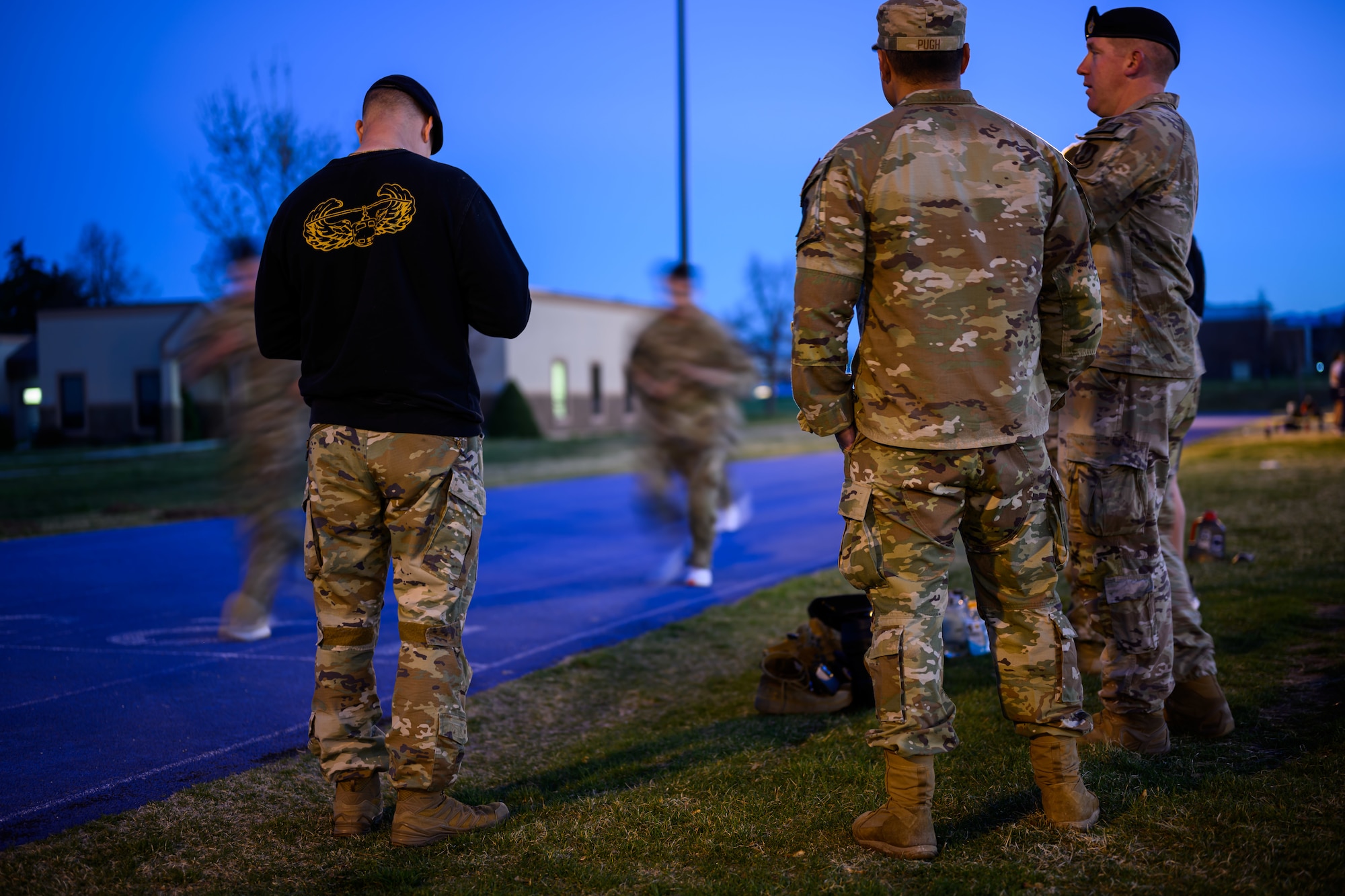 Airmen observe candidates running on a track.