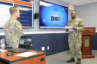 Lt. Cmdr. Patrick Baker, left, Department Head of Mental Health practices a Primary Care Mental Health role-playing scenario with Hospitalman Kevin Sessoms. The interactive practice session allowed Sessoms to work through patient assessment protocols, risk screening, and triage communication strategies in a low-stakes training environment. The evolution was conducted as part of Navy Medicine Readiness and Training Command (NMRTC) Patuxent River’s "Warrior Wednesday" initiative, designed to help corpsmen build practical experience and confidence in managing behavioral health visits