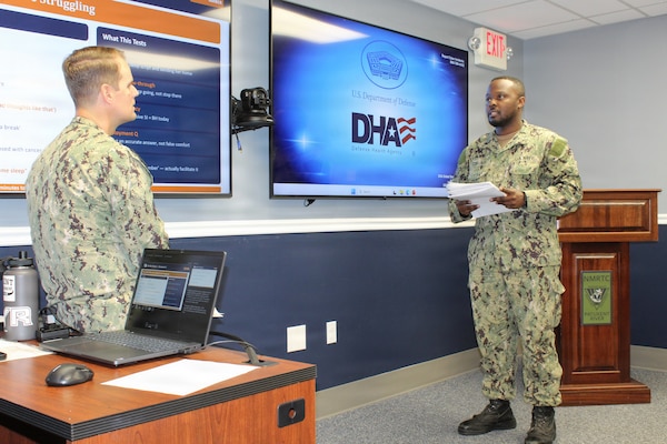 Lt. Cmdr. Patrick Baker, left, Department Head of Mental Health practices a Primary Care Mental Health role-playing scenario with Hospitalman Kevin Sessoms. The interactive practice session allowed Sessoms to work through patient assessment protocols, risk screening, and triage communication strategies in a low-stakes training environment. The evolution was conducted as part of Navy Medicine Readiness and Training Command (NMRTC) Patuxent River’s "Warrior Wednesday" initiative, designed to help corpsmen build practical experience and confidence in managing behavioral health visits