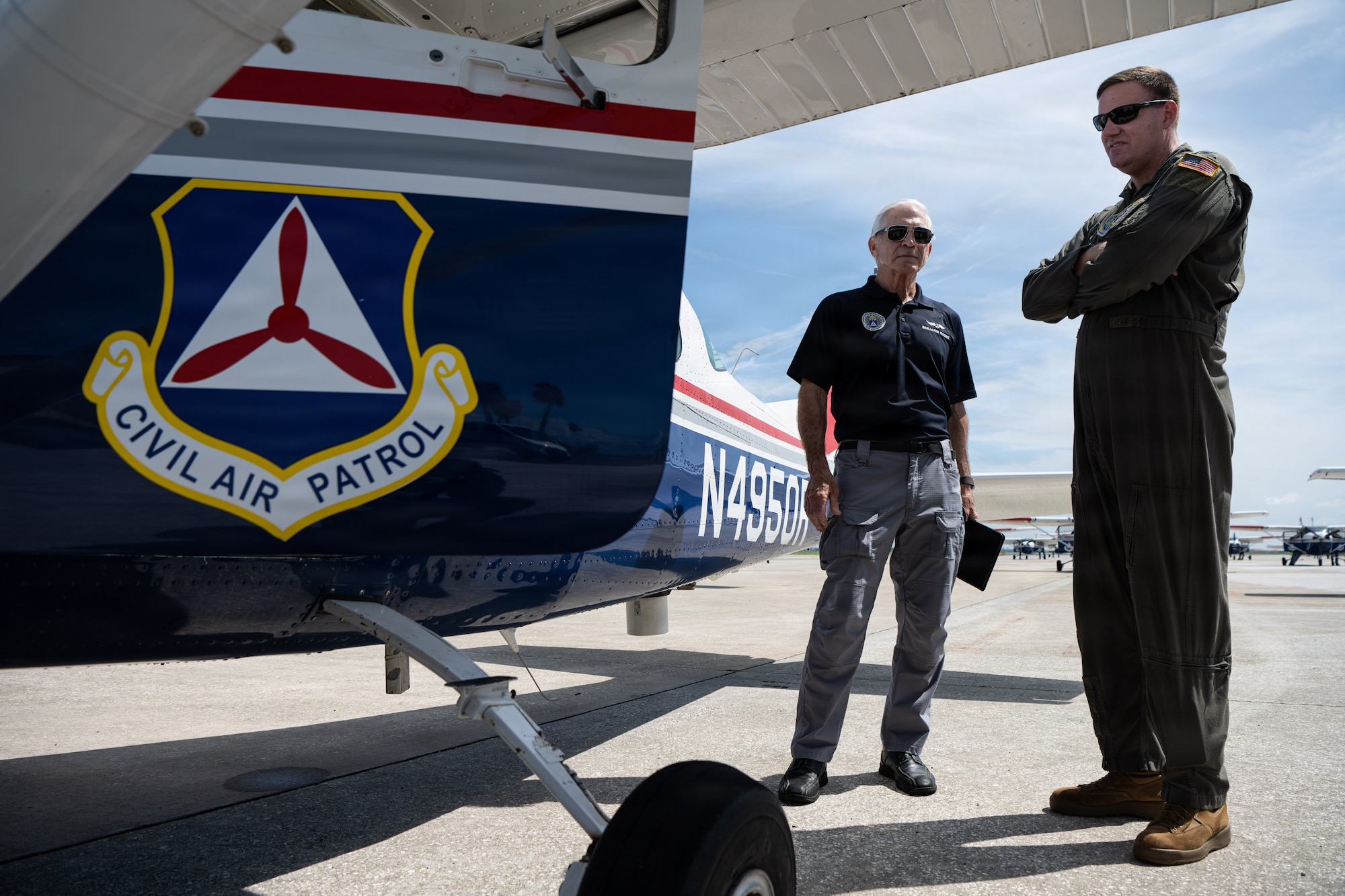 Civil Air Patrol Maj. Benjamin Moore, Sarasota Composite Squadron mission scanner and observer, left, and U.S. Air Force Col. Kevin Eley, 6th Air Refueling Wing commander, stand alongside a CAP Cessna C-206 during pre-flight inspections at MacDill Air Force Base, Florida, July 25, 2026. The crew reviewed flight coordinates and weather data to prepare for Operation Steadfast Eagle’s simulated search and rescue operations. (U.S. Air Force Photo by Airman 1st Class Helen Ly)