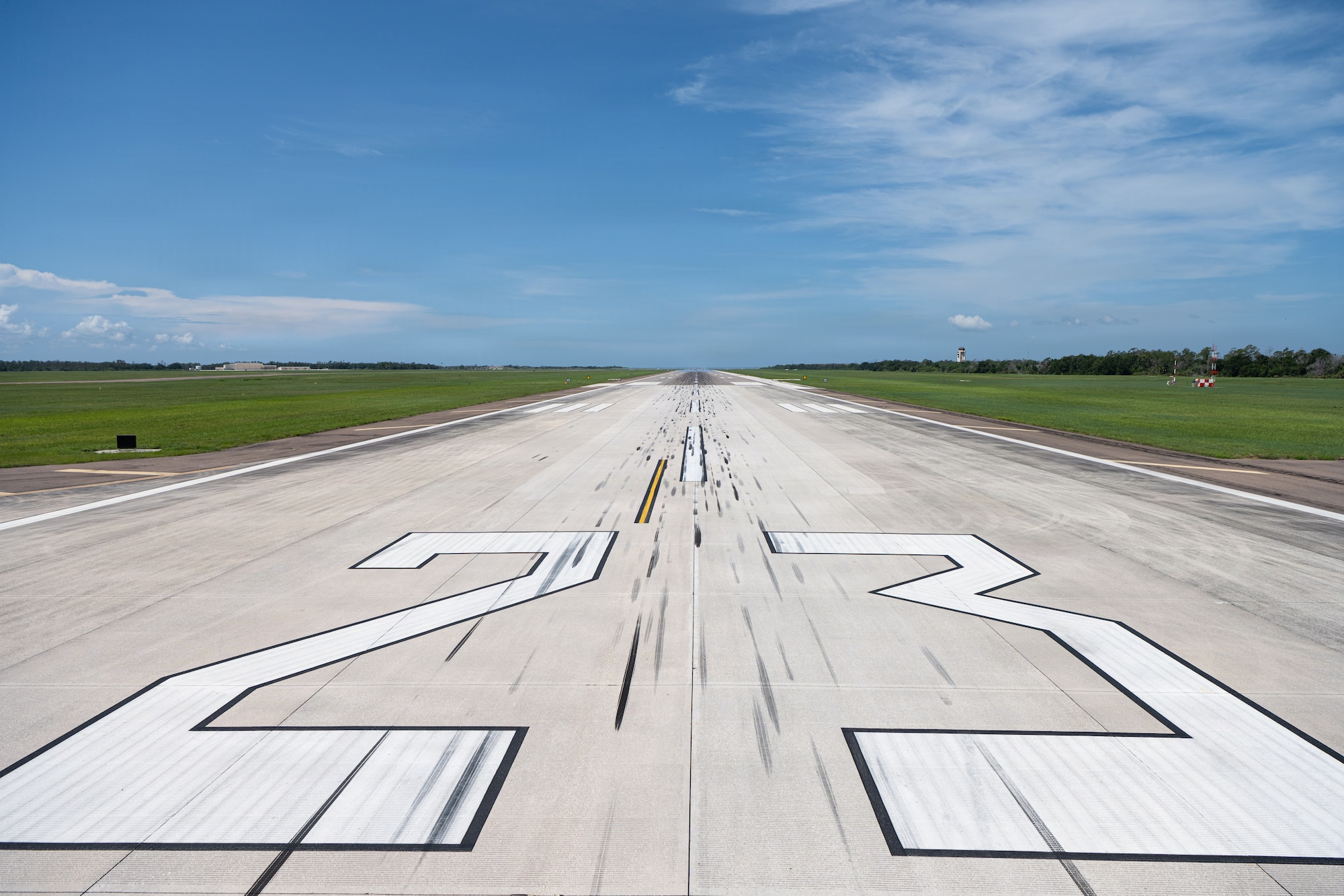 Large white numbers mark Runway 23 on MacDill Air Force Base, Florida, July 25, 2026. The number 23 indicates that the runway aligns with a magnetic heading of approximately 230 degrees, pointing pilots southwest across Hillsborough Bay toward the St. Petersburg skyline during takeoffs and landings. (U.S. Air Force Photo by Airman 1st Class Helen Ly)