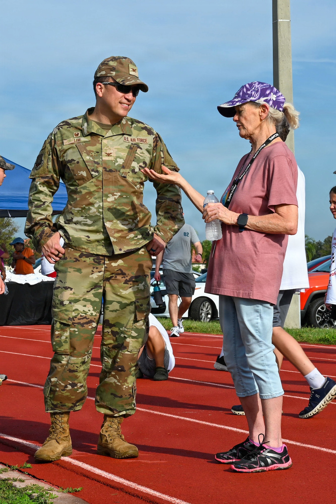 U.S. Air Force Col. BJ Lim, 6th Mission Support Group commander, speaks with Cathy Conger, a volunteer, during the Prosports NFL Football camp on MacDill Air Force Base, Florida, July 25, 2026. A’Shawn Robinson, Tampa Bay Buccaneers defensive end, hosted the camp to support military families and provide fundamental coaching to military dependents. (U.S. Air Force photo by Airman 1st Class Alexis McDonnell)
